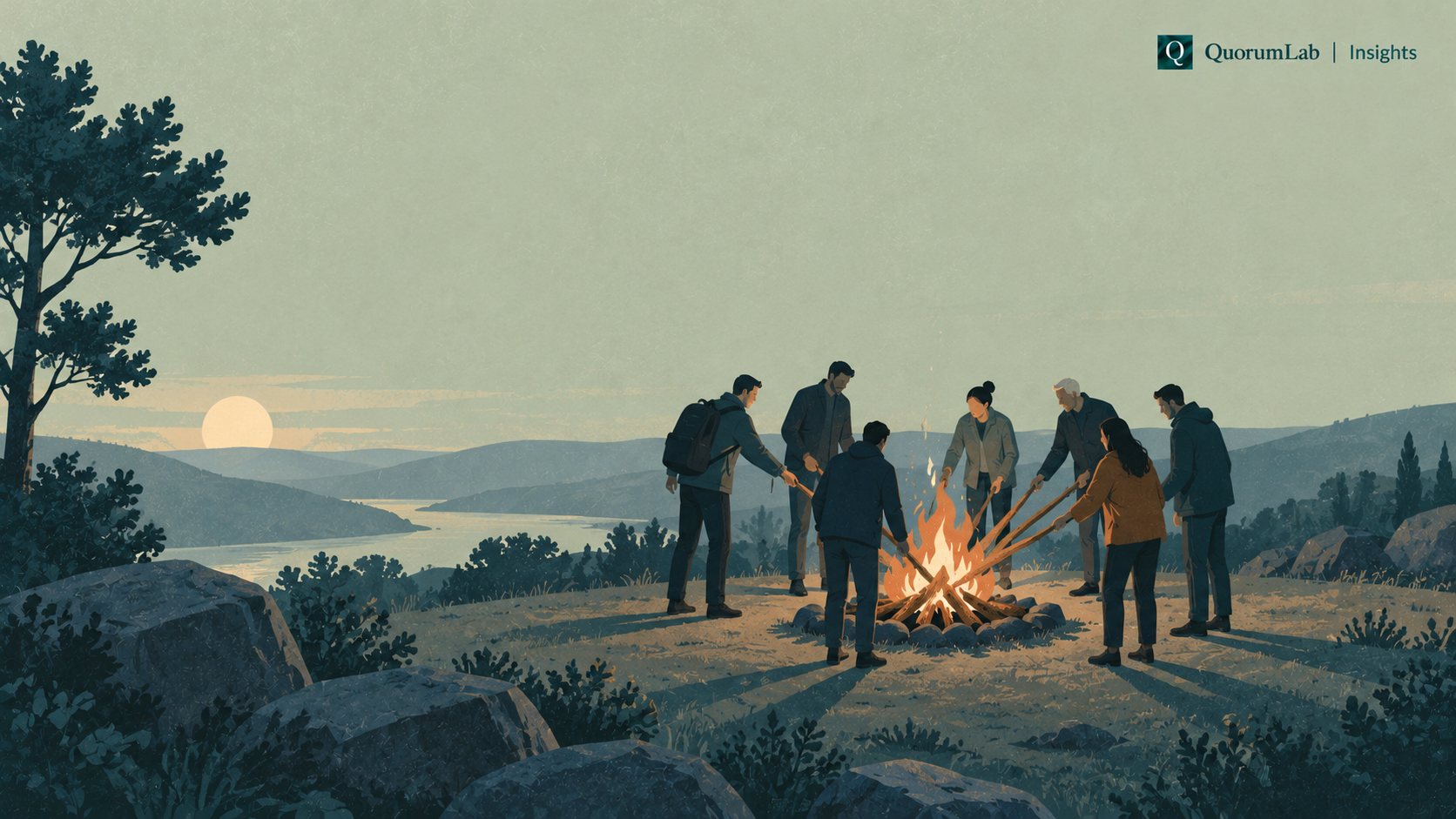 A group of people stand around a campfire at dusk, several of them adding branches to the fire at once, so no single person keeps it burning.